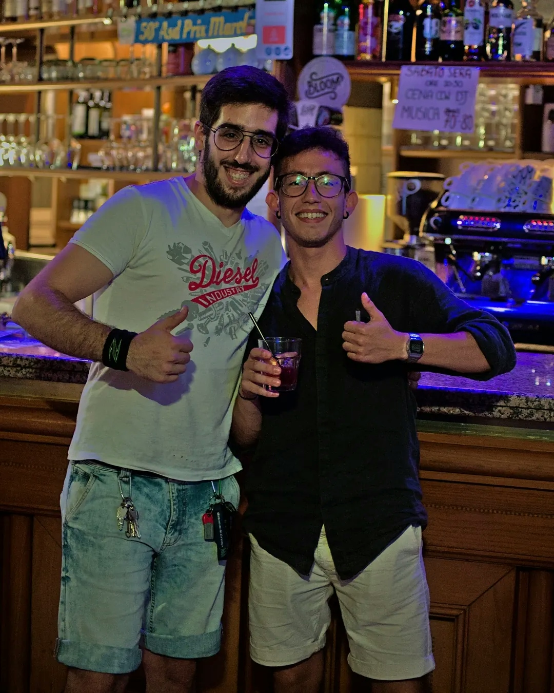 Due amici posano per la fotocamera dentro un bar